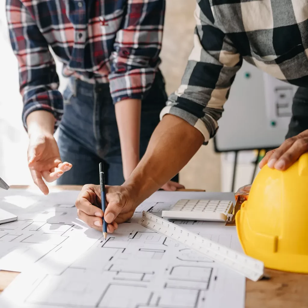 Réunion de chantier avec un maître d'œuvre et son équipe discutant des mesures de sécurité et des étapes à suivre pour assurer la sécurité du site.